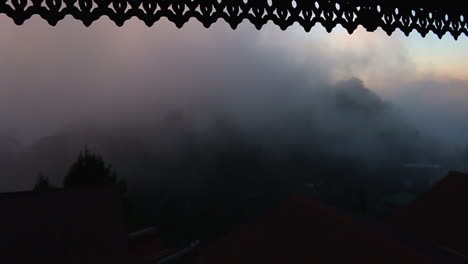 view of dense fog movement from a window during the early morning hours in mussoorie, india, slow motion shot.