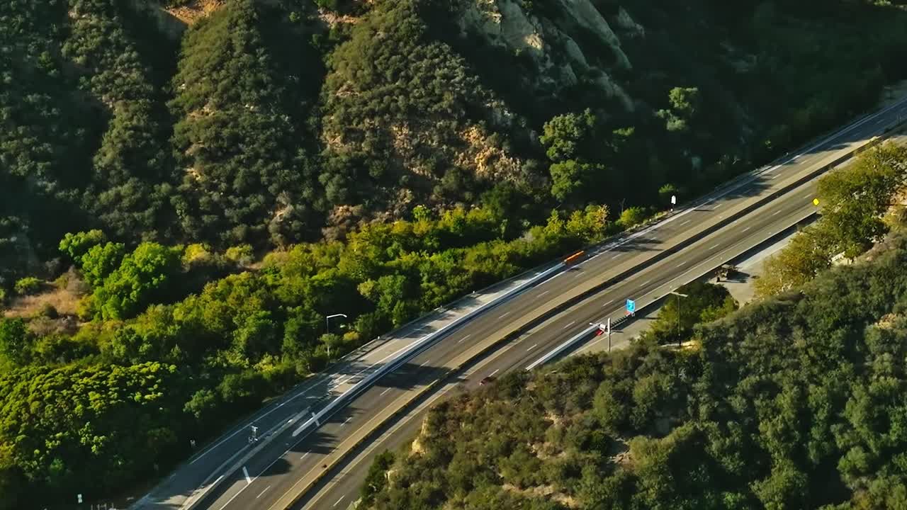Vista aerea di un'autostrada che si snoda tra le colline in California durante il giorno.