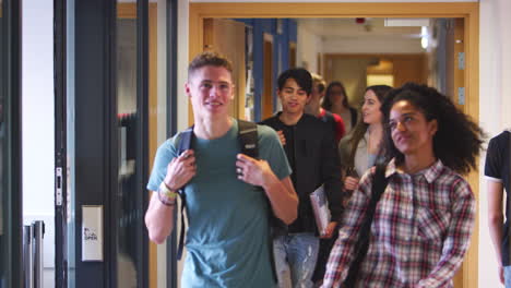 grupo de estudiantes universitarios caminando por el corredor de la universidad