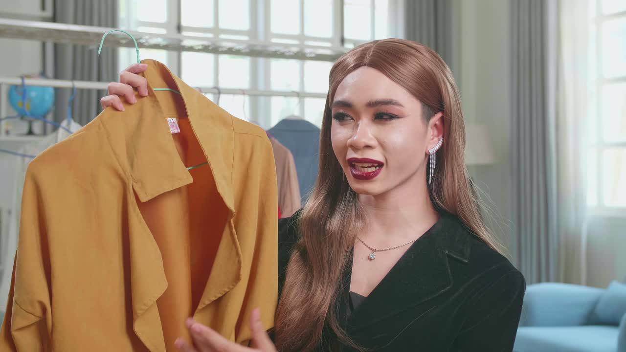 Fashion Blogger Transgender Woman Showing Casual Colorful Shirts On Camera. Stylist Influencer Shemale Showing Trendy Clothes Filming Vlog Episode