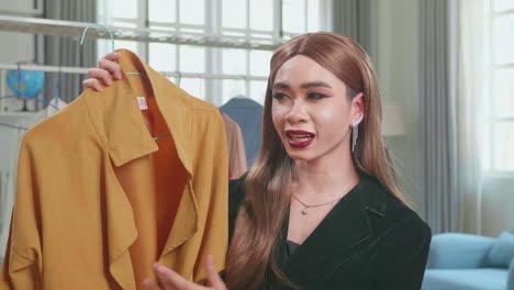 fashion blogger transgender woman showing casual colorful shirts on camera. stylist influencer shemale showing trendy clothes filming vlog episode