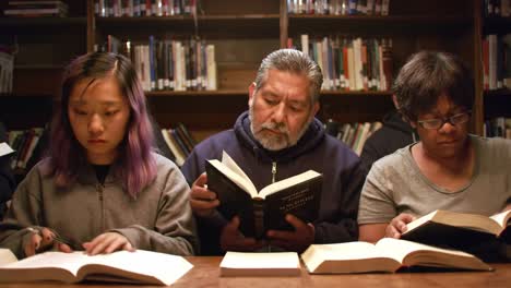 focused readers engrossed in books in a cozy library setting, highlighting the joy of literature across generations with intense concentration and engagement
