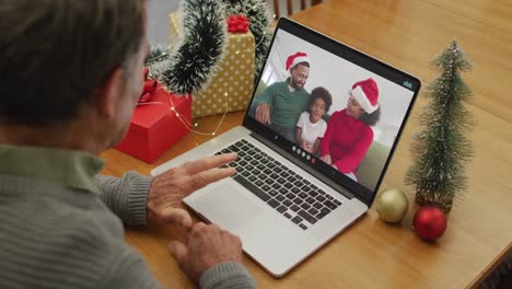 Happy-caucasian-senior-man-on-video-call-with-family-at-christmas-time