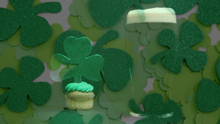 Camera revealing cupcake and pint glass, shamrock cutouts drifting forward to create festive reveal