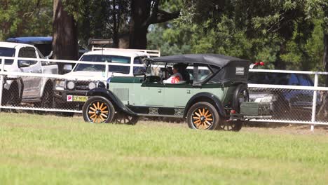 green sports car speeds up on a racetrack