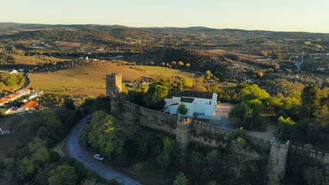 fotografía de un avión no tripulado de una capilla blanca construida en una colina con muralla y torre medieval en alentejo, portugal