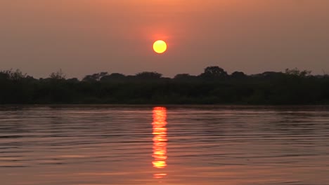 colorful sunrise over water from boat at river nile uganda