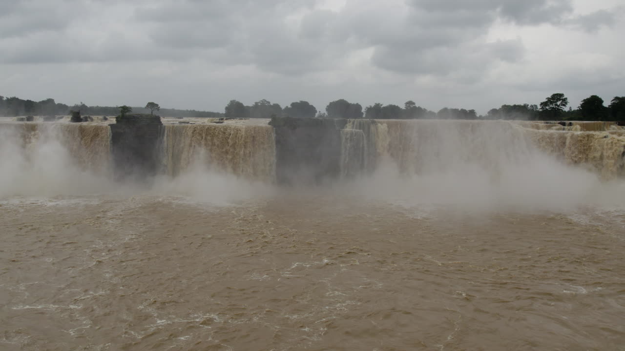 Cnematic eye-level drone shot of a waterfall