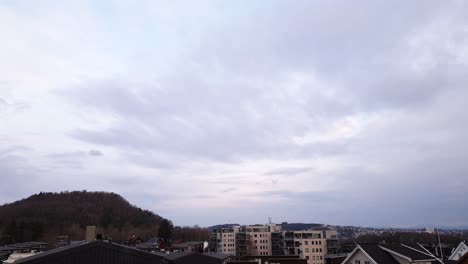 Lapso-De-Tiempo-Del-Amanecer-De-Las-Nubes-Sobre-La-Colina-Y-Los-Edificios-Residenciales-En-Gausel,-Suburbios-De-La-Ciudad-De-Stavanger,-Noruega