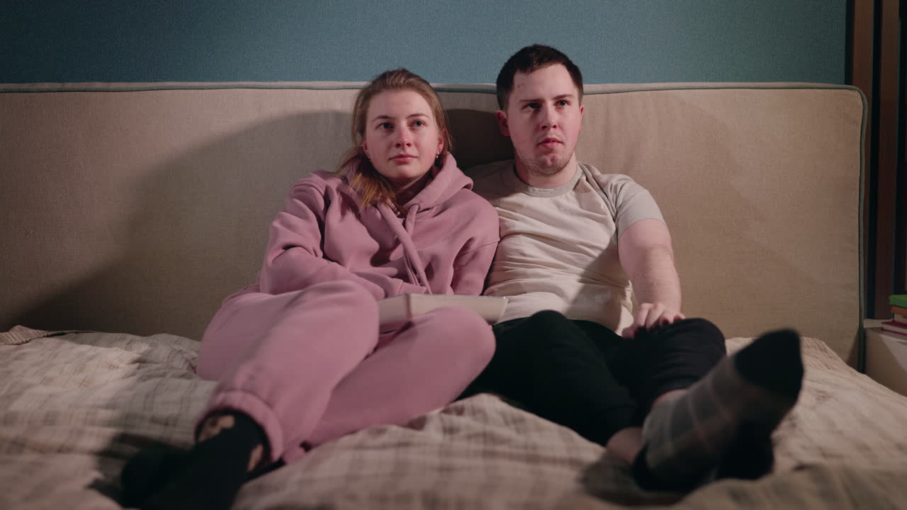 침대에서 영화를 보는 커플