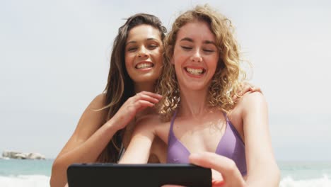 Front-view-of-two-Mixed-race-female-friends-taking-selfie-with-mobile-phone-on-the-beach-4k