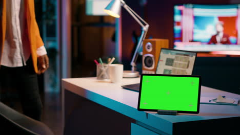 African american pupil looks at greenscreen display on tablet