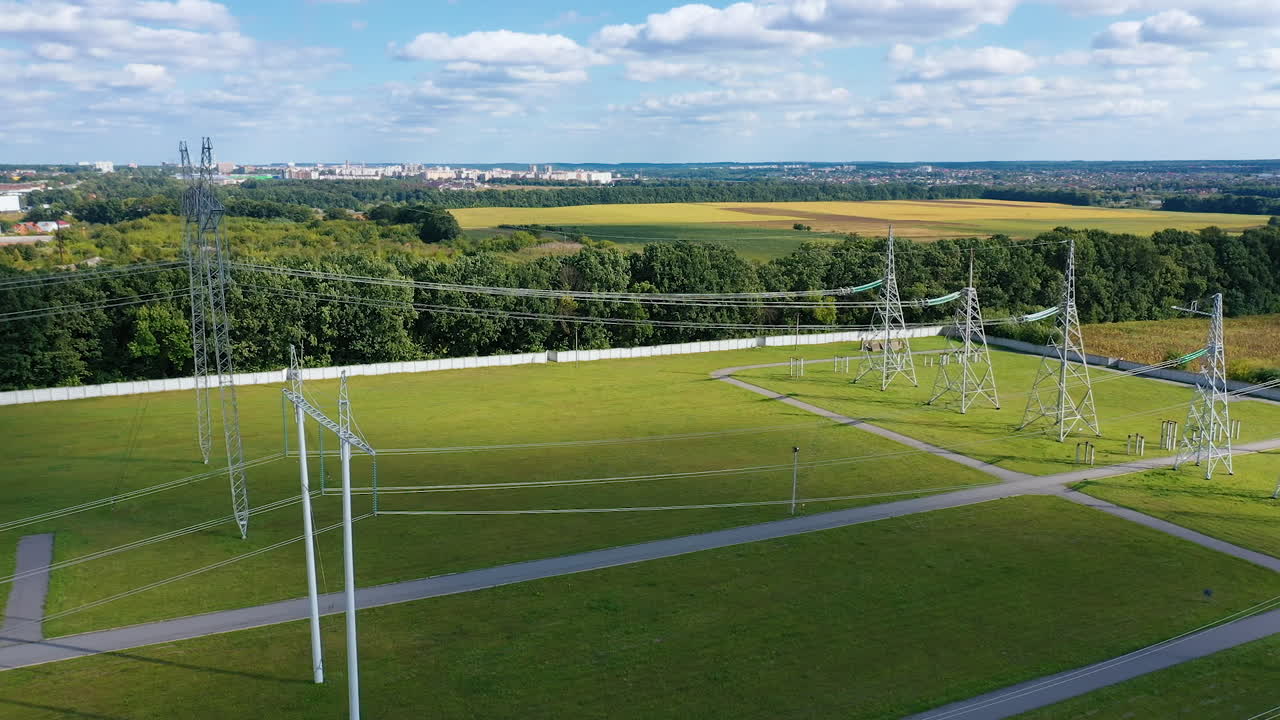 Electric transmission towers on a green field. Power lines supply with wires. High voltage electric pylons in the countryside.