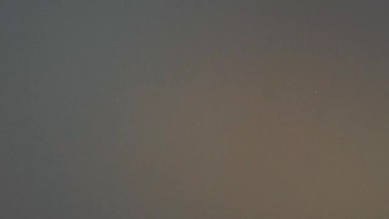 Cielo notturno con stelle deboli e un leggero bagliore di luce