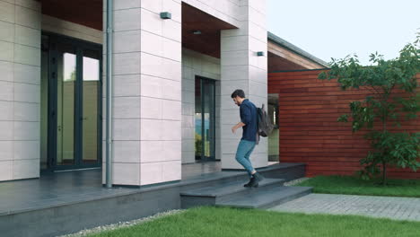 Business-man-entering-office-building-with-backpack.