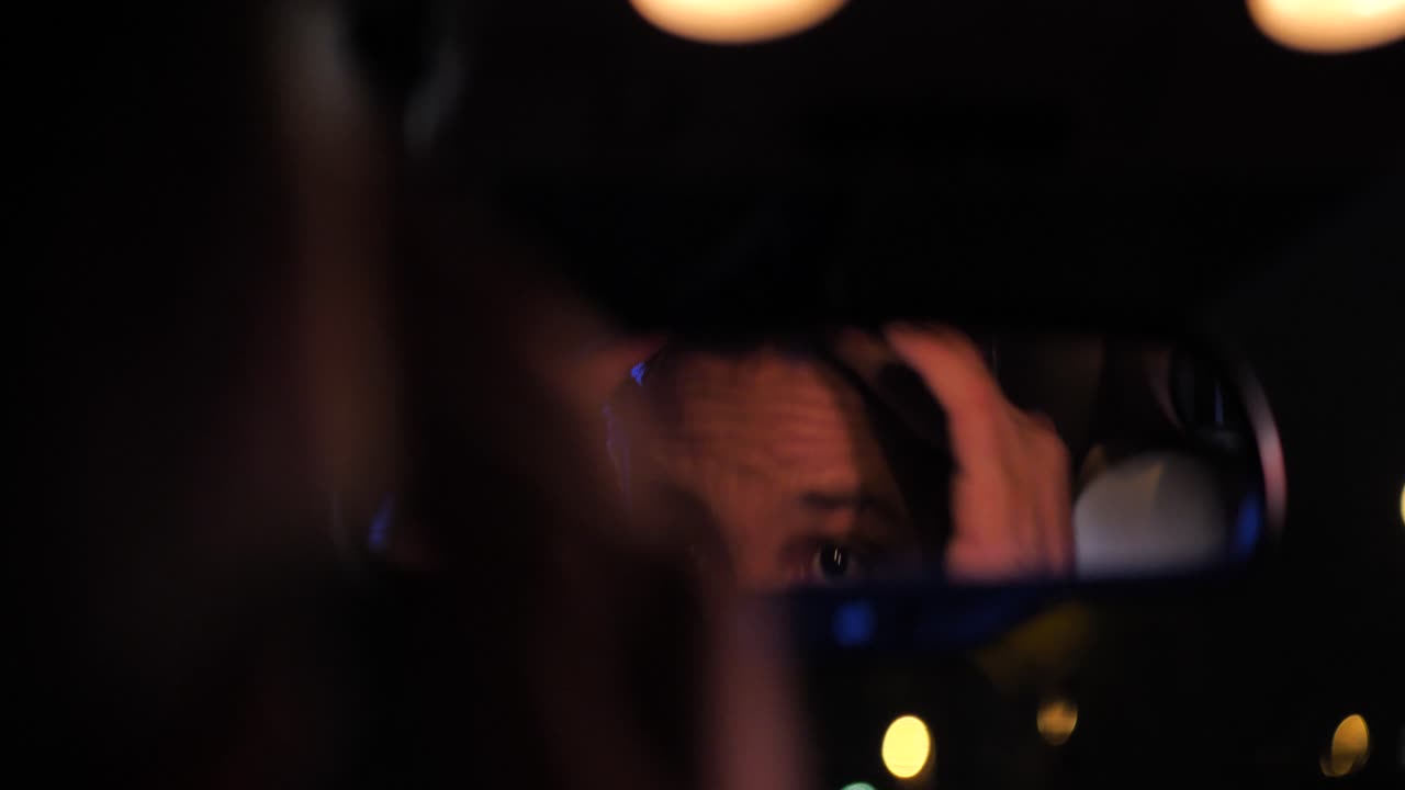 회의 또는 데이트 전에 헤어 스타일과 눈썹을 조정 밤에 차에 남자