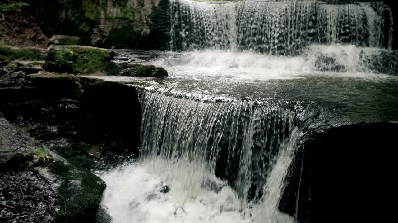 cámara lenta de una joven turista disfrutando de una vista épica de una cascada.