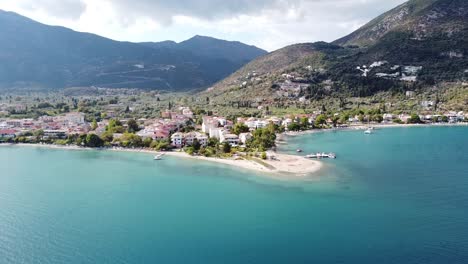 Sandy-Beach-and-Cityscape-of-Nidri-at-Lefkada-Island,-Greece---Aerial