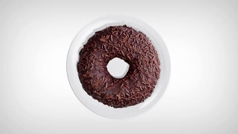 delicious chocolate donut rotating on a white plate. donut close-up. top view