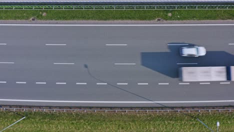 Rising-aerial-view-above-vehicles-driving-in-one-direction-on-Icelandic-highway,-Top-down-Birdseye