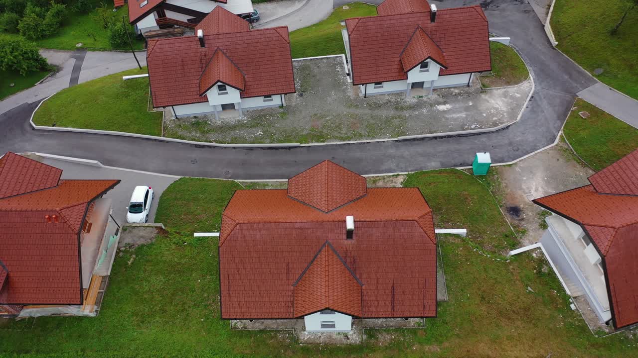 Drone aerial descending tilt up bird eye view of a small village with cluster of houses