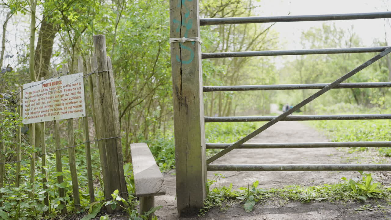 Wooden Gate in a Forest Path with Notice