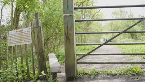 wooden gate in a forest path with notice
