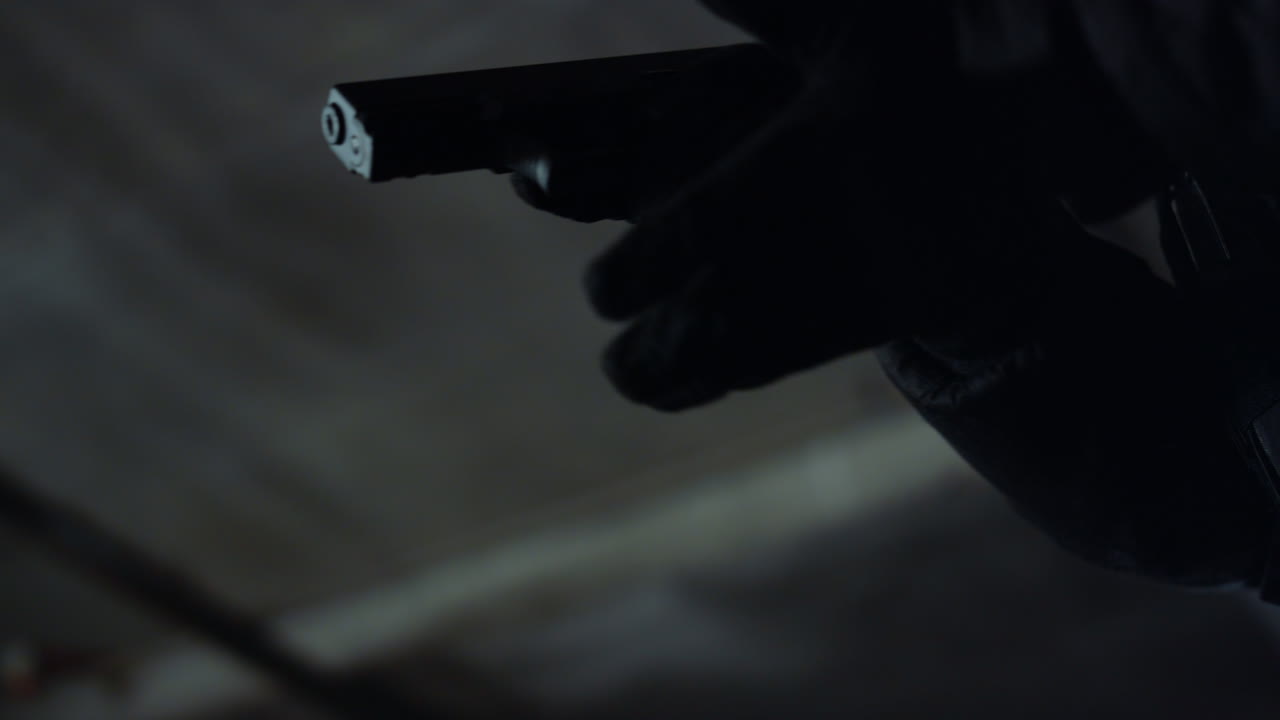 asesino con guantes cargando el cargador del arma. soldado poniendo el cargador en la pistola