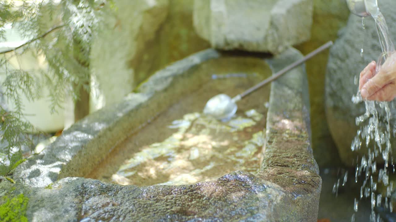 일본 교토의 전통적인 석재 싱크대에서 손을 씻는 것, 일본 한낮의 햇빛 슬로우 모션 4k