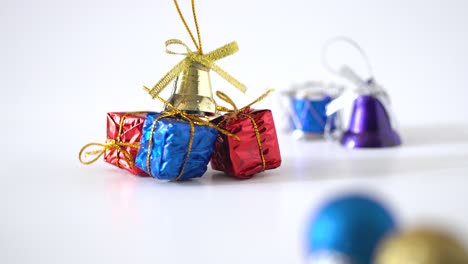 close up view and panning studio shot of christmas decorations on white background : golden ribbons, bell, snare drum and shining ball