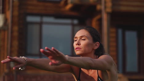 Hermosa-Morena-En-El-Fondo-De-Una-Gran-Mansión,-Ocupada-En-El-Gimnasio-Y-Realizando-Sentadillas,-Hace-Ejercicio-Al-Aire-Libre-Fortaleciendo-Los-Músculos-De-Las-Caderas