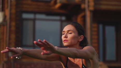 hermosa morena en el fondo de una gran mansión, involucrada en el gimnasio y realizar sentadillas, ejercicio al aire libre fortaleciendo los músculos de las caderas