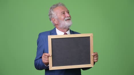 hombre de negocios barbudo y guapo contra un fondo verde.