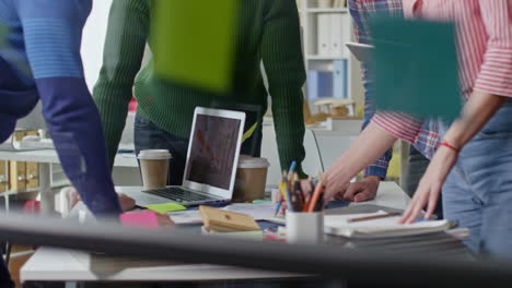 group of coworkers stand around the table