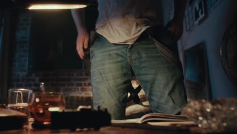 man reading and smoking in his dark apartment at night.