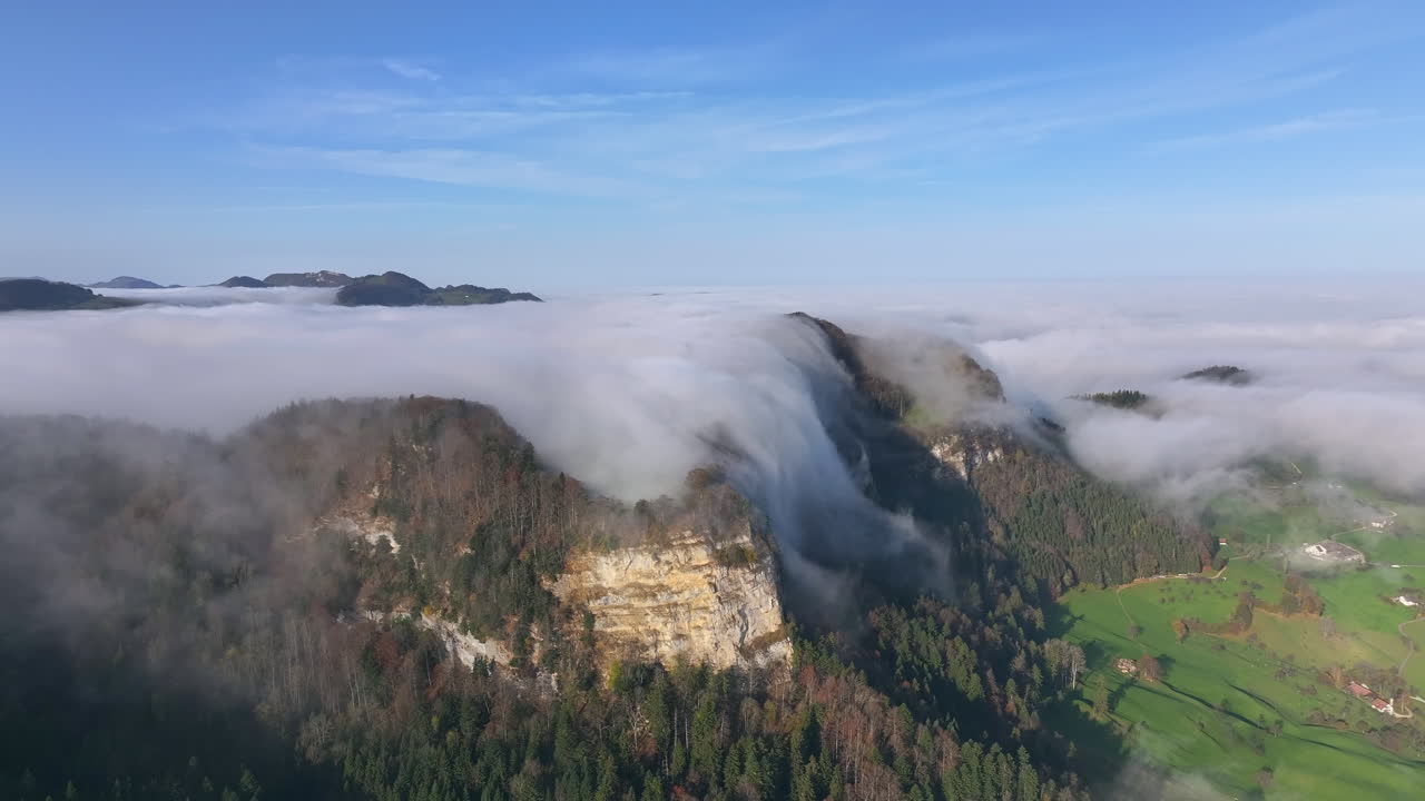 Fog rolls over the Jura mountains in a breathtaking aerial view on a clear day