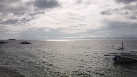 Slow-push-in-on-boats-cruising-along-shore-in-Philippines