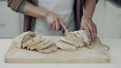 bread, knife and hands of person in kitchen