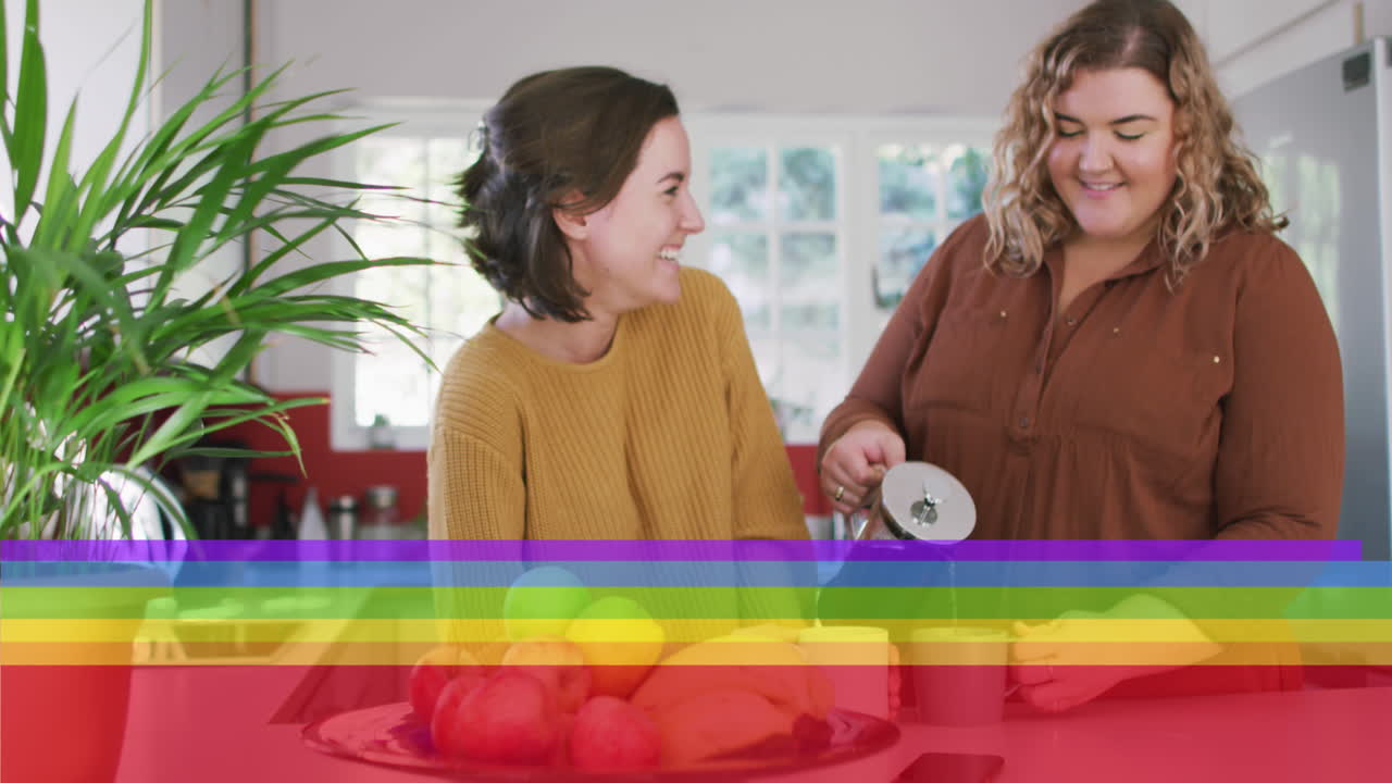 animación de la bandera del arco iris sobre una pareja de lesbianas preparando café en la cocina