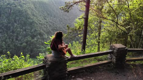 casual young woman playing countryside music with her guitar on nature landscape. - aerial drone