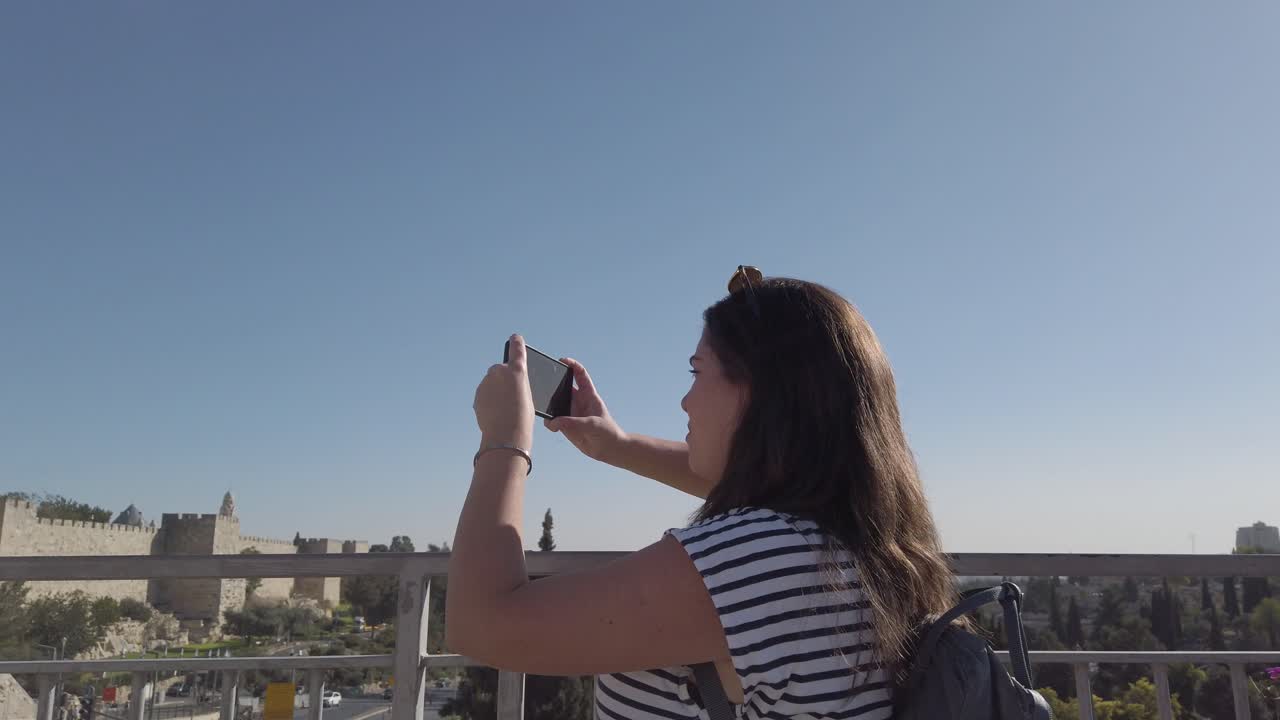 mujer tomando una foto de la ciudad vieja de jerusalem