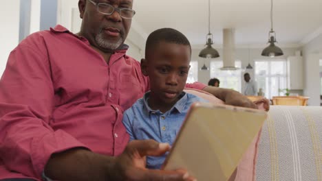 video of african american grandfather and grandson using tablet together