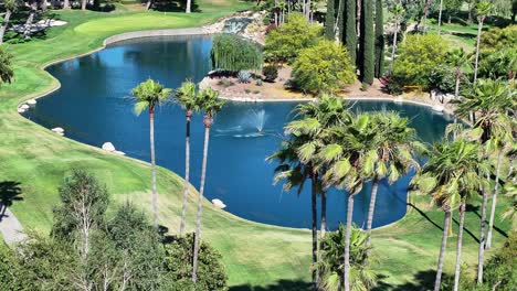 aerial-telephoto-of-a-large-pond-with-a-fountain-on-a-luxurious-golf-course-mid-day-AERIAL-STATIC