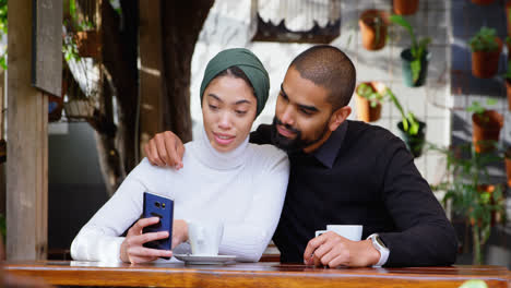 Couple-discussing-over-mobile-phone-in-cafeteria-4k