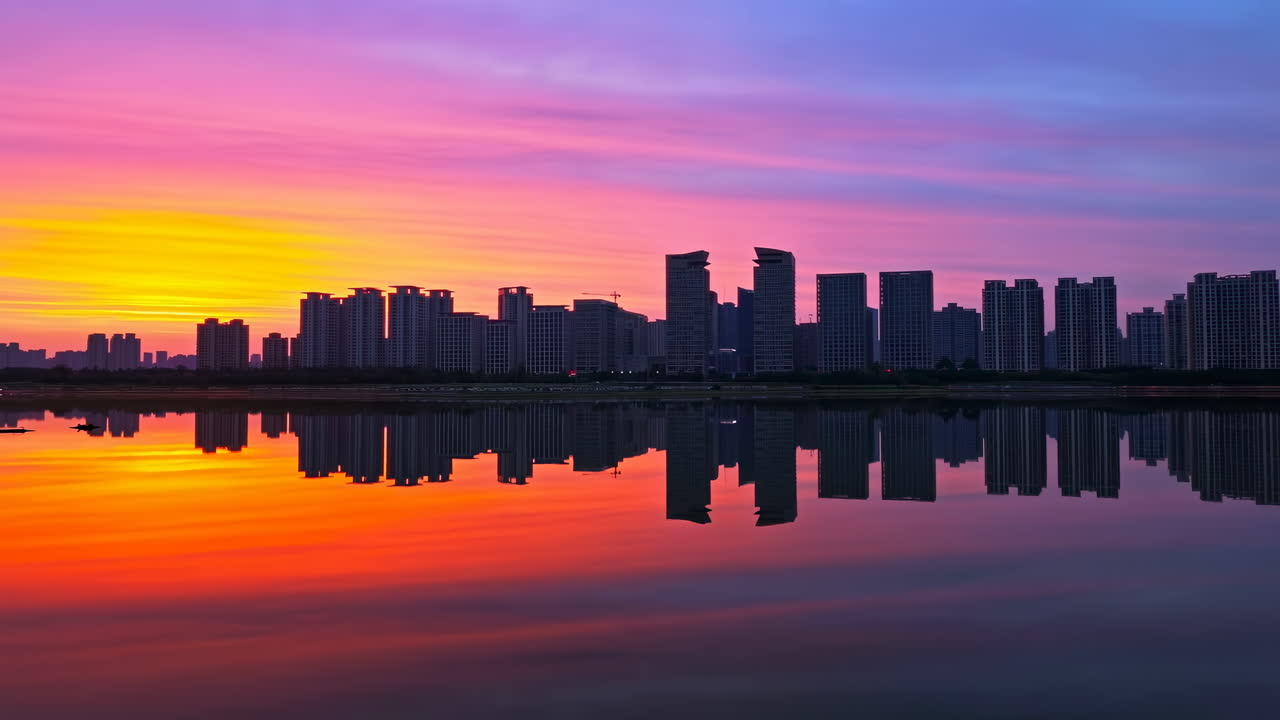 Horizonte ao Pôr do Sol Refletido no Lago Céu com Gradiente Magenta e Laranja Sobre Silhuetas de Arranha-céus Modernos Espelhadas