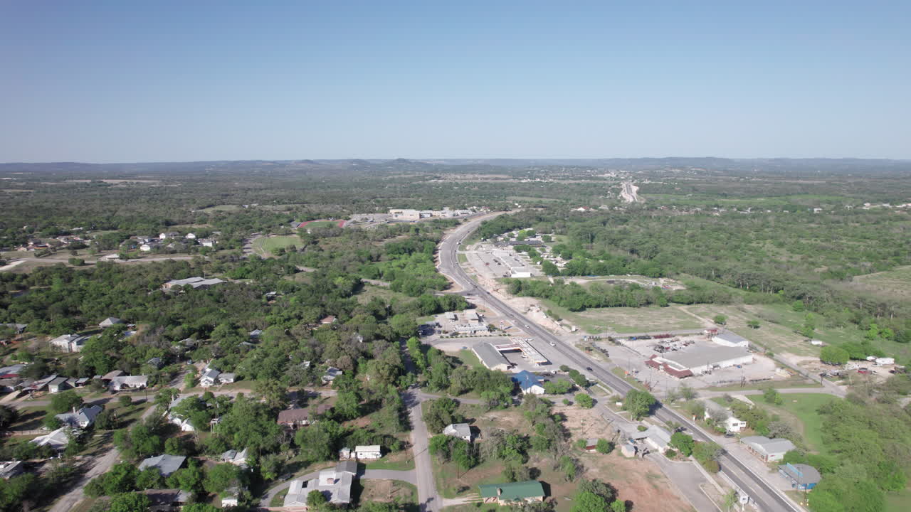 Aerial View of Bandera, Texas in the Hill Country, push in on highway leading in to town