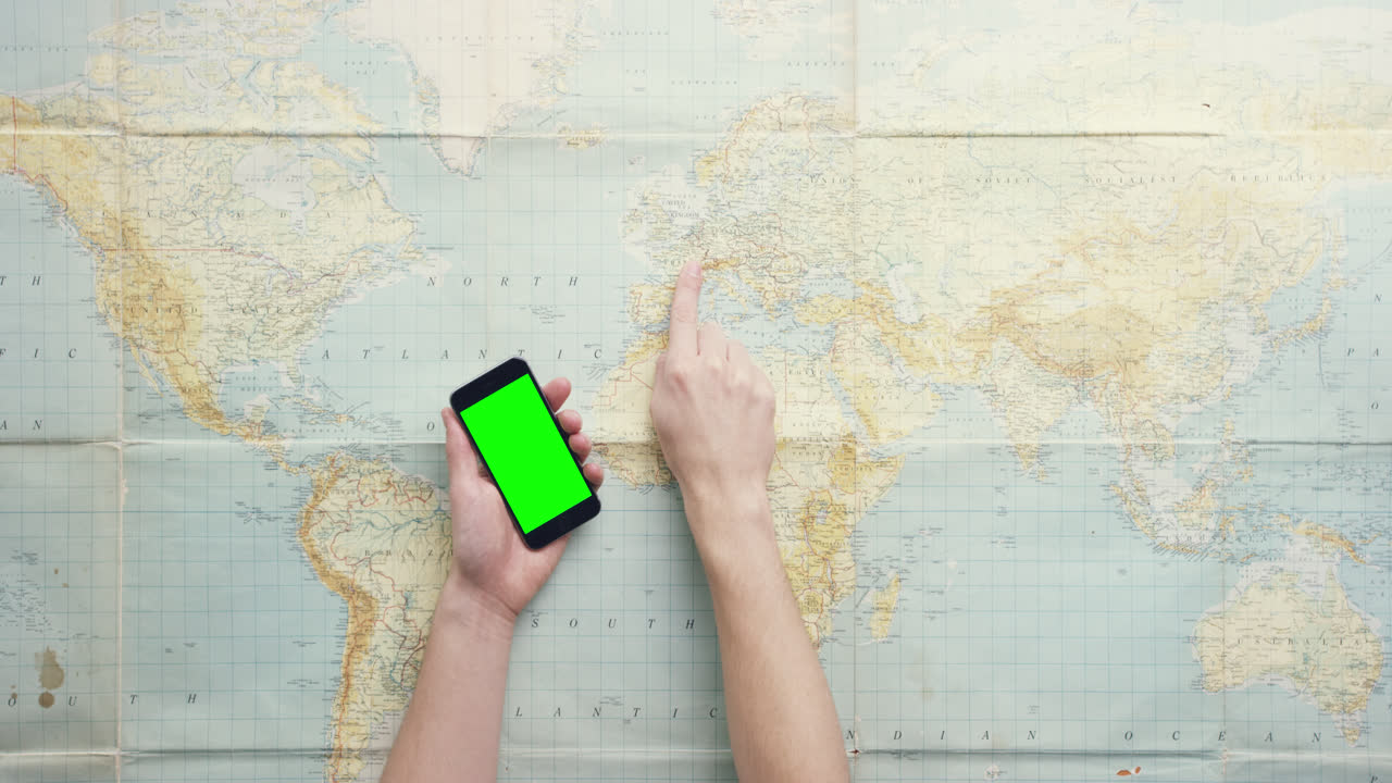 vista superior manos usando teléfono móvil pantalla táctil digital navegando mapa mundial mundial trabajando en el escritorio desde arriba - dragón épico rojo