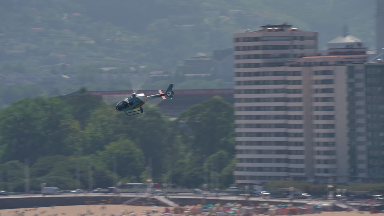 Helicopter flying over a city and coastline