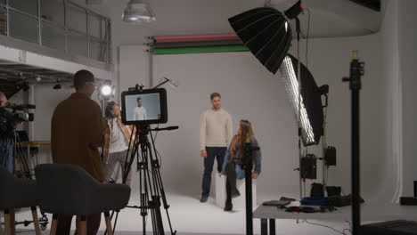 female assistant uses clapperboard as actors shoot movie or video in studio with film crew and director shot in real time 1