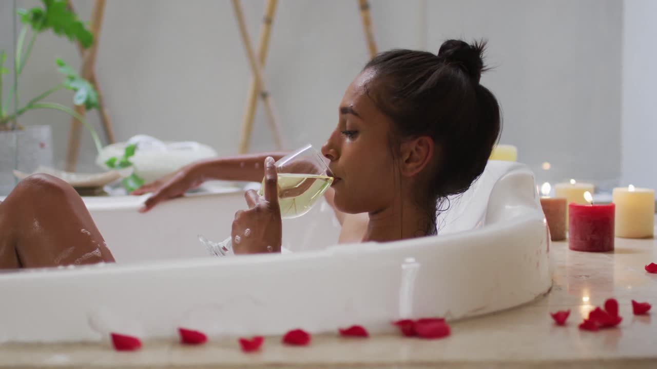 Mixed race woman lying in a bathtub at home